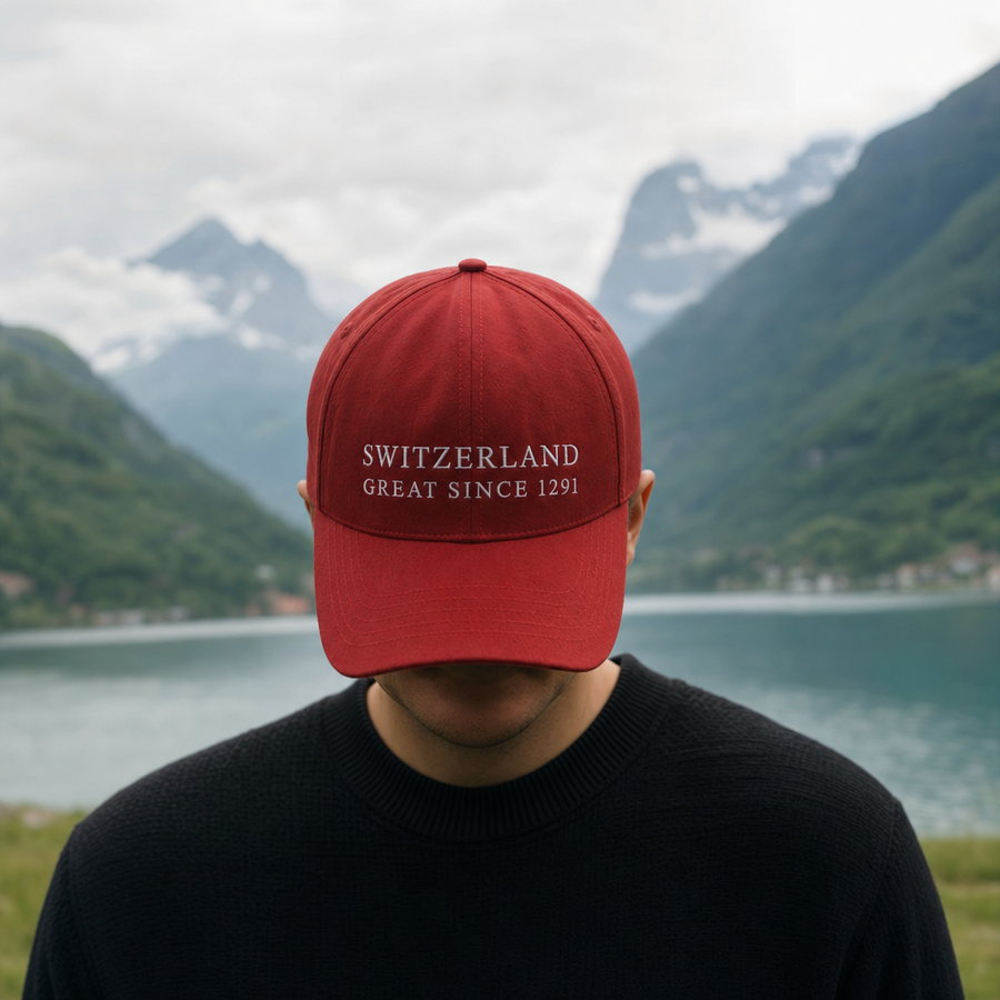 Casquette rouge SWITZERLAND GREAT SINCE 1291 portee au bord d'un lac suisse