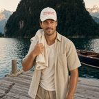 Casquette blanche à broderie rouge portée sur un ponton au bord d'un lac suisse